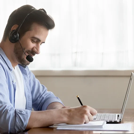Man working on laptop with headset
